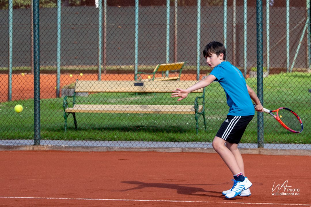 Kind beim Tennis spielen